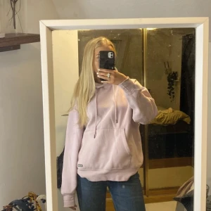 Ljusrosa hoodie - Säljer en supermysig ljusrosa hoodie i bra skick. Den har en stor ficka fram och justerbar huva med snören. Perfekt för kyliga dagar eller bara för att chilla hemma. Passar till det mesta! 🌸 Som ni ser inte så bra skick, unisex.