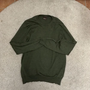 Grön tröja från Oscar Jacobson - Säljer en stilren grön tröja från Oscar Jacobson i storlek M. Tröjan är tillverkad i Italien och har en klassisk design med långa ärmar och rund hals. Perfekt för både vardag och lite finare tillfällen. Passar bra till höst och vår! Pris kan diskuteras