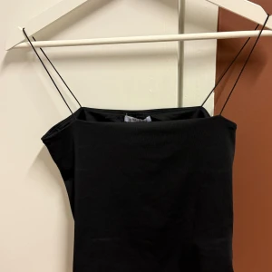 Svart tubtopp från Amisu - Snygg svart tubtopp från Amisu i storlek M. Perfekt för sommaren eller en utekväll. Den är stilren och enkel att matcha med olika outfits. Toppen har en tight passform och är tillverkad i ett mjukt material.