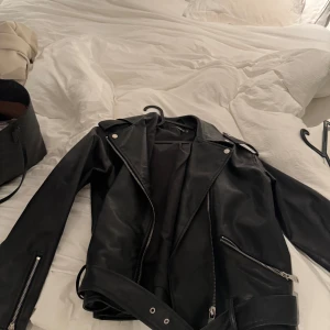 Svart skinnjacka med dragkedja - Säljer en snygg svart skinnjacka i mycket bra skick. Jackan är ifrån missguided och är använd 1 gång