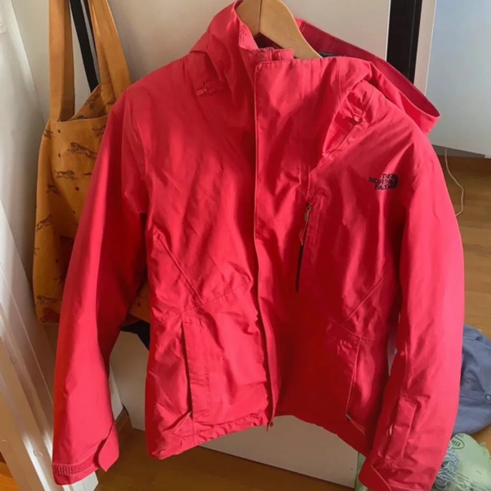 Säljer en snygg röd jacka från The North Face i storlek S. Perfekt skidjacka med vind- och vattenavvisande yta. Jackan har en praktisk huva och dragkedja framtill. Den är i mycket bra skick och redo för nya äventyr! 🌟Det finns nått tecken på användning men tycker ändå den är i bra skick. . Jackor.