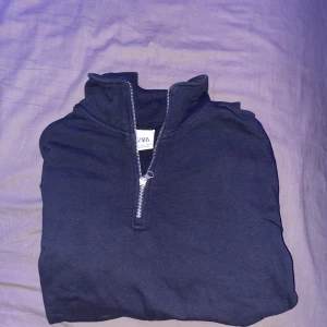 Mörkblå tröja med dragkedja från Zara - Säljer en mörkblå tröja från Zara i väldigtbra skick. Den har en praktisk dragkedja framtill och långa ärmar, perfekt för höst och vinter. Tröjan är stilren och passar till många olika outfits. Perfekt för både vardag och lite mer avslappnade tillfällen. Storlek S