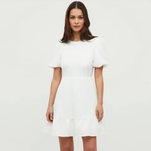 Vit klänning - Super fin vitt klänning med rosett i ryggen, puffamar och volang längst ned! Perfekt till studenten