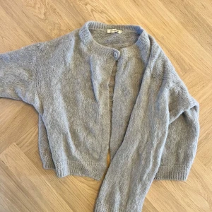 Design by si kofta - Mysig grå kofta med en knapp från design by si. Använd fåtal gånger. Mysigt fluffigt material. 