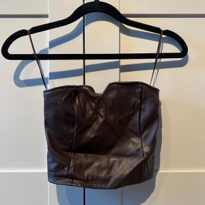 Brun axelbandslös topp -  Brun axelbandslös topp i skinn