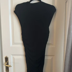 Svart klänning från Gina Tricot - Säljer en elegant svart klänning från Gina Tricot i storlek M. Klänningen är ifrån soft touch kollektionen. Den är perfekt för både vardag och festliga tillfällen. Klänningen har en åtsittande passform och är tillverkad i ett strechtigr material. 