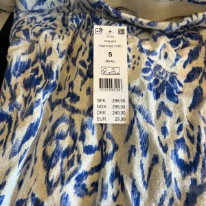 Mini skirt Gina Tricot - Snygg kjol i vitt med blåa mönster. Har resår och en Knyt i mitten. Helt ny! 