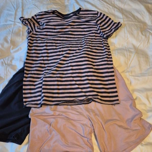 Randig t-shirt från Name It - Säljer en superfin randig pyjamasfrån Name It i marin blå och rosa. Den är kortärmad och mysig. Materialet är mjukt och skönt, vilket gör den bekväm att ha på sig hela dagen. 