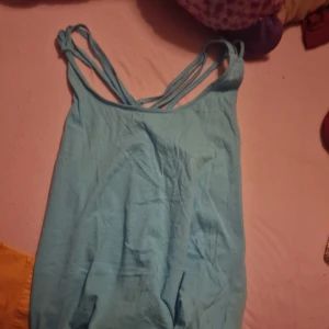 Ljusblå linnetopp från Gina Tricot - Säljer en ljusblå linnetopp från Gina Tricot i storlek S. Toppen är tillverkad av ekologisk bomull och har dubbla axelband för en snygg detalj. Perfekt för sommardagar eller som ett lager under en kofta. 🌿💙