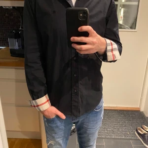 Burberry skjorta - Hej, säljer nu min skjorta från Burberry. Skjortan är i fint skick och har lite täcken på tvätt. Den är i storlek M men passar mig som är ca 175. Den är givetsvis äkta. Tveka inte att fråga om ni har några funderingar🤩👌