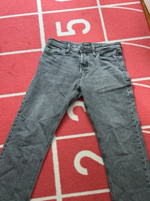 Grå relaxed jeans från Jack & Jones - Säljer ett par gråa relaxed fit jeans från Jack & Jones, modell Chris.. Perfekta för en avslappnad och trendig stil.