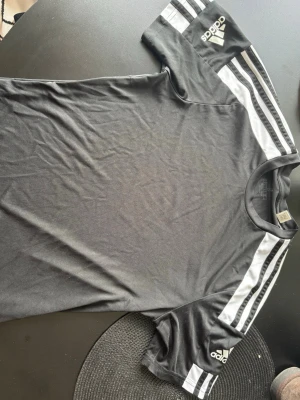 Svart Adidas t-shirt med vita ränder - Svart tränings tishrt ifrån Adidas storlek M, bra skick. Kill- modell.