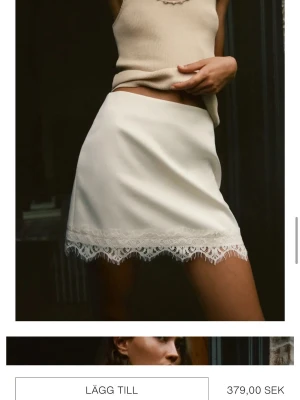 Vit kortkjol med spetskant - Supersnygg vit kortkjol med spetsdetalj längst ner. Kjolen har en enkel och clean look med en feminin touch tack vare spetsen. Perfekt att styla med ett linne eller en croppad topp för en trendig outfit. Kjolen är helt oanvänd och har lappen kvar. Nypris 379