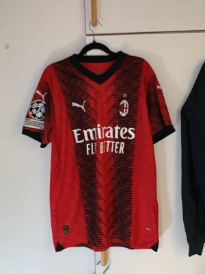 L. Äkta AC Milan 2023/2024 2nd kit  - Har använt max 5 gånger totalt 10 timmar Jag är en fotbolls tröja samlare i över 15år nu väljer jag och sälja den pågrund av min ps5 gick sönder för 2 dagar sen behöver köpa en ny därför väljer jag sälja den här en av några fotbolls tröjor Röd och svart AC Milan matchtröja från Puma med Ibrahimović och nummer 11 på ryggen. Tröjan har svarta detaljer, klubbmärke och sponsorloggor framtill samt Champions League-märke på ärmen. Perfekt för fotbollsfans!