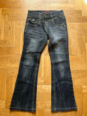 Mörkblå bootcut jeans med kontrastsömmar - Snygga mörkblå bootcut jeans med slitningar och markerade kontrastsömmar. De är omärkta och köptes i en vintagebutik i London. De passade mig när jag var ca 155-160 cm lång och hade storlek xs.