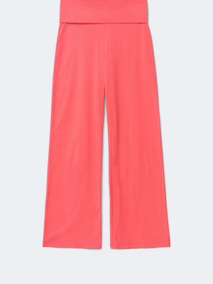 Vida korallfärgade mjukisbyxor Gina Tricot - Säljer ett par mjukisbyxor i en snygg korallfärg i storlek S från Gina Tricot. Byxorna har hög midja med bred linning och vida ben. Tillverkade i mjukt bomullsmaterial som är skönt mot huden. Använda enstaka gång men har en  liten fläck (se bild 3), därav det låga priset. 