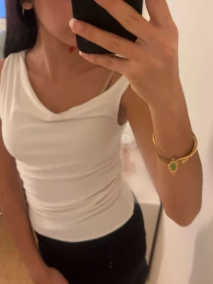 Vit ärmlös linnetopp - säljer en enkel och stilren vit linnetopp med ärmlös design och rundad halsringning. Perfekt att matcha med jeans eller kjol för en clean look.