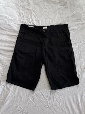 Chinoshorts  - Svarta regular chinoshorts från Jack & Jones. Storlek M.
