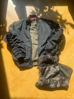Komplett Outfit  - Fräsig outfit med svart bomberjacka storlek L från lager 157, mörkgrön T-shirt storlek L från brandit och militär byxor storlek L från SHEIN. Tveka inte att fråga om något!                             inga förhandlingar.