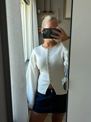 Figursydd kofta - Vit figursydd kofta från Gina. Den har en liten fläck på baksidan av ena armen men som man inte tänker på när man har den på. Säljer då jag inte använder den längre💕
