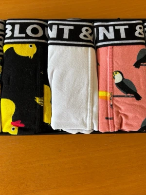 Flerpack kalsonger med tropiskt motiv - Säljer ett flerpack kalsonger från Blount & Pool i storlek 3XL. Paketet innehåller 5 par i olika färger och mönster: svart med papegojor, vit, rosa med tukaner och ett par med tropiskt motiv. Alla har bred resår med logga och är tillverkade i mjuk bomullsblandning. Ligger fint förpackade och kan enkelt ges bort som en presentförpackning. 