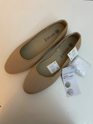 Beige ballerinaskor från Esmara, stl 41 - Snygga beige ballerinaskor från Esmara med rund tå och diskret textur i materialet. Skorna har en klassisk och enkel design som passar till många olika outfits. Tillverkade i ett mjukt tygmaterial för extra komfort. Säljs med tbättpåse 