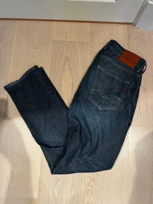 Mörkblå raka jeans från Replay - Säljer ett par mörkblå jeans från Replay med klassisk femficksmodell och raka ben. Jeansen är i gott skick och strl 33 men passar 32 utmärkt. Bara att skriva vid minsta lilla.