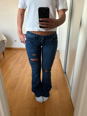 Blå slitna bootcut jeans - Snygga mörkblå jeans med egengjorda slitningar på benen.🤩