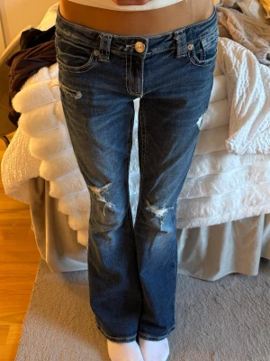 Mörkblå bootcut jeans med slitningar - Jättefina jeans från Gina 14+, kommer tyvärr inte till användning längre. Innerbenslängd: 80, midjemått: 39
