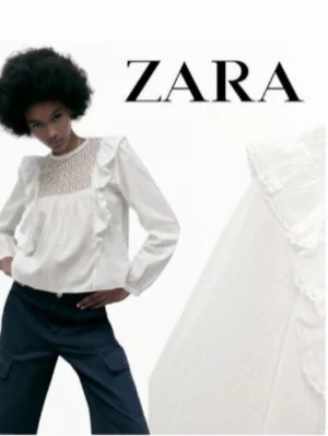 Vit blus med spets och volanger Zara - Trendig vit blus från Zara med långärmad design, spetsdetaljer upptill och volanger längs axlar och bröst. Tillverkad i ett lätt, strukturerat tyg som ger en luftig känsla. Perfekt för dig som gillar romantisk och stilren look.