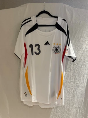 Tyskland landlags tröja Ballack - Säljer en vit Tyskland fotbollströja med nummer 13 Ballack på ryggen. Tröjan är 73.5 cm lång och 54 cm bred och modellen på bilden är 189 cm lång och väger 77kg. Bara att höra av sig vid frågor. 