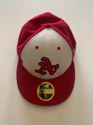 Röd och vit A's keps 59FIFTY - Snygg röd och vit keps med broderad A's-logga framtill. Klassisk 59FIFTY-modell med rak skärm och broderade ventilationshål i väldigt bra skick 