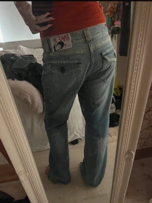 Coola vintage jeans - Säljer ett par ljusblå baggy jeans från Take Two med raka ben och coola fickdetaljer bak. Jeansen har en avslappnad passform och slitna tvätteffekter som ger en vintagekänsla. Perfekta för en chill och trendig look. Köpta i en vintage butik i Japan