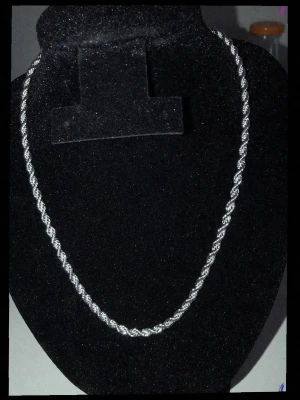 Silverfärgat Cordell halsband - Snyggt halsband nu oanvänd silver planterad ,4mm bredd och 60 cm längd. som ger ett stilrent och modernt intryck. Halsbandet har en kedja med spiralformad struktur och metallisk glans. Perfekt för att lyfta vilken outfit som helst.