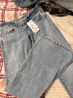 Ultra low flare jeans ljusblå - Säljer ett par ljusblå ultra low flare jeans i modellen 'Super lt blue'. Jeansen har låg midja, utsvängda ben och klassisk femficksdesign. Dem är i ”Tall”. Aldrig använda. 