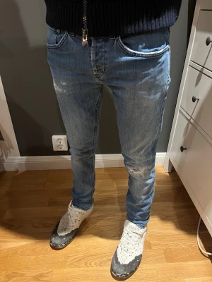 Dondup jeans - Snygga blå dondup jeans i klassisk straight fit med slitningar och lätt tvättad look. låg midja och coola detaljer på bakfickorna. Nypris på dessa ligger på 5000kr men vårat pris är 499kr!!!