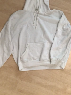 Vit hoodie från BikBok - Klassisk vit hoodie från BikBok med luva. Hoodien har en stor magficka och ribbade muddar vid ärmslut och nederkant. Tillverkad i mjukt och skönt material. M-L perfekt lite oversized hoodie till hösten.