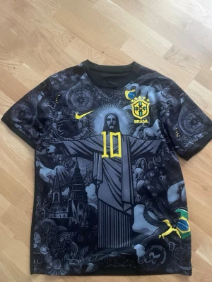 Mörkblå Brasilien fotbollströja är xl men sitter typ som L - Unik svart fotbollströja med Brasilien-tema och stort tryck av Kristusstatyn på framsidan. Gula detaljer som nummer 10, Nike-logga och Brasilien-emblem. Kortärmad och tillverkad i ett lätt, andningsbart material. Perfekt för dig som vill sticka ut på planen.
