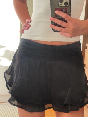Svart mini kjol med volanger - Säljer denhär superfina svarta kjolen med dubbla lager och volangkant. Baktill är det midjeresår så den sitter perfekt! Gina young strlk 170. HELT NY ENDAST PROVAD