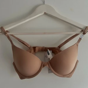 victoria's secret pink bh - helt oanvänd victoria's secret pink bh i storlek 34A med prislappen kvar. modellen heter "wear everywhere lightly lined full coverage t-shirt bra" och är i färgen praline med "pink" på sidan. säljer då den var för liten för mig och hann ej returnera 💗 nypris 400kr