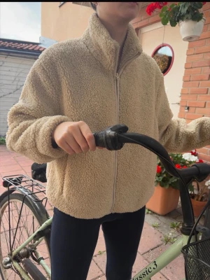 Teddy jacka - En fleecejacka från stradivarius, den har inga defekter och går att göra mindre eller större i midjan inifrån. Den har fickor. Jag är 163cm