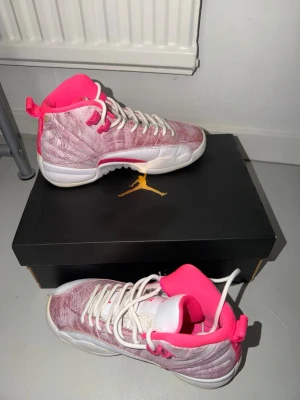 Jordan sneakers rosa och vit - Snygga Jordan sneakers i rosa och vitt med högt skaft och vita snören. Insidan är neonrosa och ovandelen har en sammetsliknande finish. Klassisk Jumpman-logga på lådan. Perfekta för dig som vill sticka ut med färg och stil.