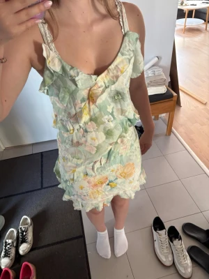 Blommig kort klänning med volanger - Söt kort klänning med blommigt mönster i pastelliga toner. Storlek S från H&M.