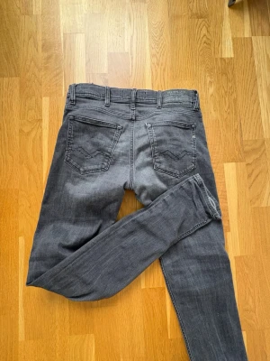 Svarta  slim fit jeans - Snygga svarta slim fit jeans med klassisk femficksdesign och bälteshällor. Jeansen har diskreta slitningar och raka ben, perfekta för en avslappnad och trendig look. Materialet är mjukt och stretchigt för extra komfort.