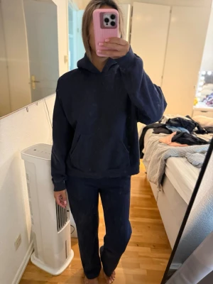 Mörkblått set - Mysigt mjukis set i mörkblå färg med en oversized hoodie och matchande byxor. Hoodien har en stor ficka framtill och byxorna är raka i modellen. Perfekt för chill dagar hemma eller när du vill vara bekväm. Byxorna storlek xxs passa mig som bruka ha S i vanligt fall och är ca 163 och hoodie storlek S