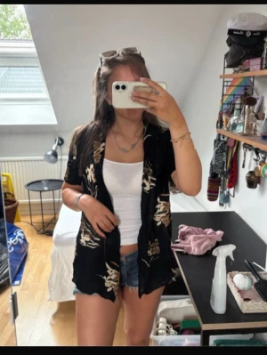 Svart skjorta med kort ärm - Super söt mönstrad blus med knappar. Säljer då den tyvärr ej används. Jag vill gärna bli av med allt jag säljer så fort som möjligt så skicka gärna prisförslag och köp gärna bundle för bundle-rabatter!💕💕