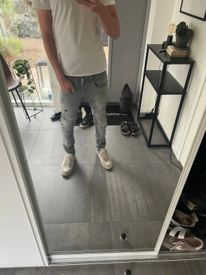 Dondup jeans  - Säljer ett par grå dondup med slitningar och hål på flera ställen. Jeansen har en tvättad look och snygg passform som sitter nice längs benen. Perfekta för en avslappnad och trendig streetstil.