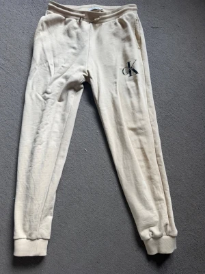 Beige mjukisbyxor Calvin Klein - Beige mjukisbyxor Calvin Klein. Passar från 160-170 