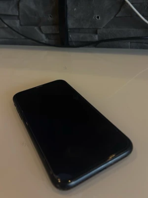 Svart iPhone XR med originalkartong - Säljer en svart iPhone XR med stilren design och rundade kanter. Telefonen har en stor skärm, glasbaksida och klassisk Apple-logga. Levereras med originalkartong. Perfekt för dig som vill ha en snygg och pålitlig smartphone. Den har smårepor samt så är de skärmskydd på den just nu så vet inte om de finns något större skador under skärmskyddet 