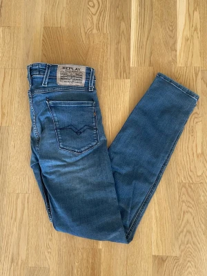 Blå Replay Anbass jeans W28 L32 - Jag säljer dom här riktigt fräscha Replay Anbass jeansen i storlek W28 L32. De är i fint skick utan skador. Tveka inte att höra av er!                          Mått: Längd=98cm. Midja=39cm.